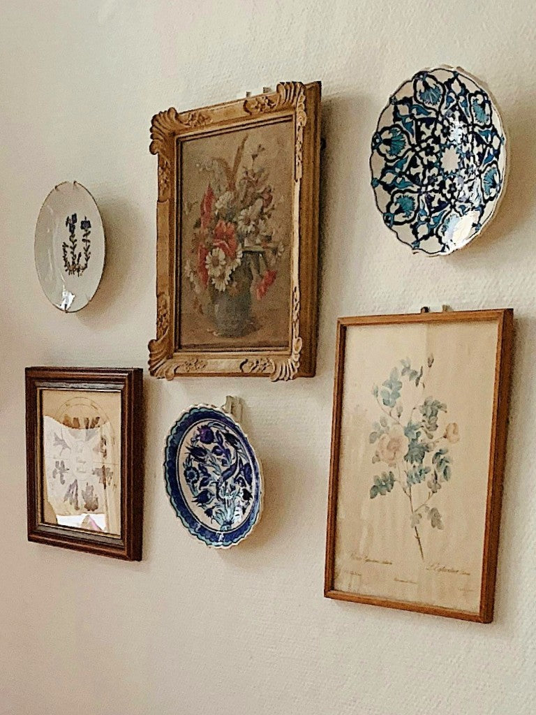 vintage plates and framed pictures hanging on a wall